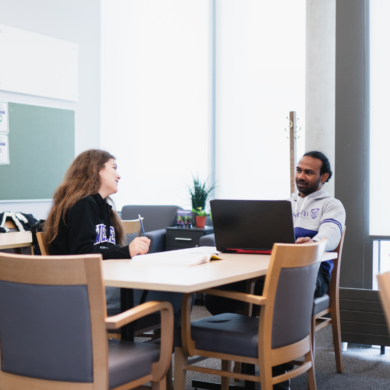 Several student peer leaders sit in a classroom.